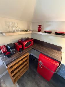 a small kitchen with a red refrigerator and shelves at Sip and Soak, hotel-style room in Calgary