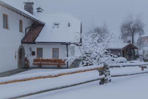 a house covered in snow with a fence at Stockerhof in San Lorenzo di Sebato