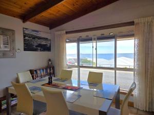 a dining room with a table and chairs and a large window at Dolphin Cove in Wallaroo