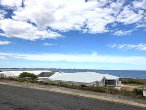 a building with a roof on the side of a road at Dolphin Cove in Wallaroo