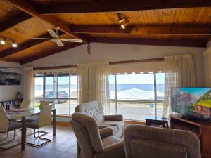 a living room with a table and chairs and a large window at Dolphin Cove in Wallaroo