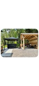 a picnic shelter with a picnic table and a bench at Chalet Havana in Namur