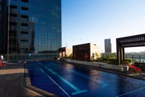 a swimming pool on the roof of a building at River View 1BR Docklands Apartment sleeps 3 in Melbourne