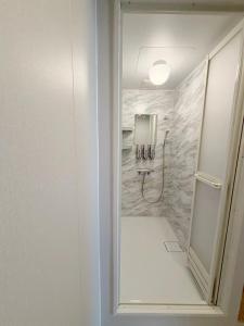 a bathroom with a shower with a sink and a shower at ゲストハウス 華園 in Furano +52 photos