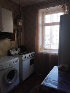 a kitchen with a washing machine and a window at Квартира in Sumy