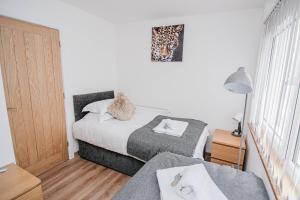 a small bedroom with two beds and a window at City Centre Apt with FREE PARKING in Doncaster