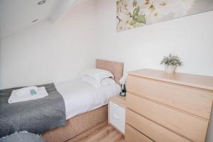 a small bedroom with a bed and a dresser at City Centre Apt with FREE PARKING in Doncaster