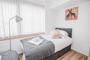 a bedroom with a bed and a window at City Centre Apt with FREE PARKING in Doncaster +12 photos