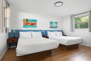 two beds in a room with two windows at Sun & Sand Resort in Port Austin +197 photos