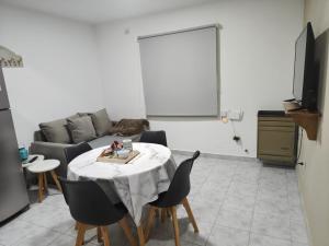 a living room with a table and a couch at Quimey Ruca Alojamientos in Neuquén