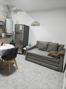 a living room with a couch and a kitchen at Quimey Ruca Alojamientos in Neuquén