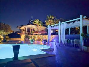 a swimming pool in front of a house at night at Travel Baiot'S in Villanova di Farra