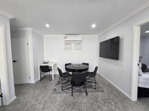 a room with a table and chairs and a bed at Matildas Urban Escape 6-Min Station & Shops in Campbelltown South
