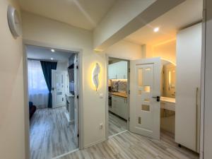 a kitchen with white cabinets and a white door at Luu's Studio! in Hunedoara
