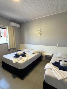 ein Schlafzimmer mit zwei Betten, auf denen Handtücher liegen in der Unterkunft Hotel Pousada Colliseu in Aparecida