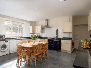 a kitchen with a wooden table and chairs in it at Endeavour - Hhy in Luton