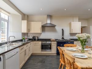 a kitchen with white cabinets and a wooden table at Endeavour - Hhy in Luton +39 photos