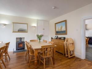 a dining room with a table and chairs and a fireplace at Endeavour - Hhy in Luton