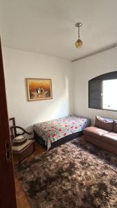 a bedroom with a bed and a couch at Pousada e Hostel Rodo in São Carlos