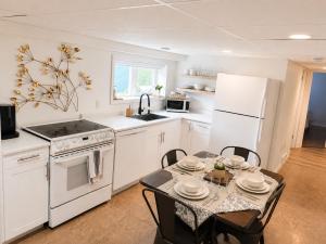a kitchen with white appliances and a table with chairs at The Bunny Street Getaway! in Kenora