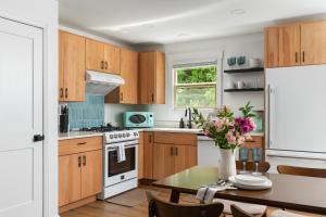 a kitchen with wooden cabinets and a table with a vase of flowers at Sun & Sand Resort in Port Austin