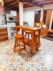 a kitchen with a wooden table and some chairs at Alojamiento en Barreal, San Juan in Barreal