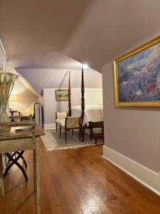 a room with a bedroom with a bed and a table at 1000 Islands Bed and Breakfast-The Bulloch House in Gananoque