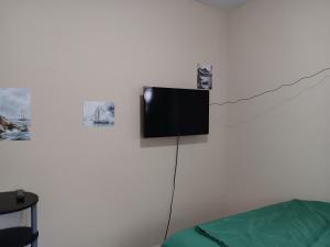 a flat screen tv hanging on a white wall at Hostel Tampa, 15 minutes to airport, near Ybor City, downtown, self check-in in Tampa