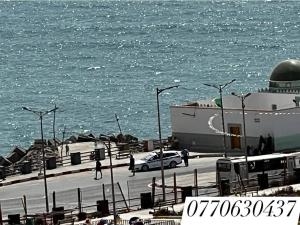 a car parked in front of a building next to the water at مستغانم حي السلام المجدوب in Sidi Mohammed Medjoub