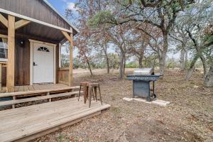 a house with a grill next to a house at Hill Country Cabin 1 in Canyon Lake