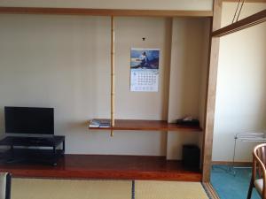 um quarto com uma televisão e uma prateleira na parede em Iyashinoyado Rodem em Morioka