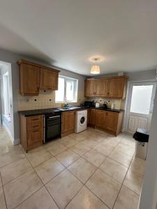 a kitchen with wooden cabinets and a dishwasher at Teach Fáilte in Sligo