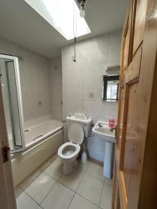 a bathroom with a toilet and a tub and a sink at Teach Fáilte in Sligo