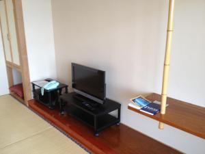 sala de estar con TV de pantalla plana sobre una mesa en Iyashinoyado Rodem en Morioka