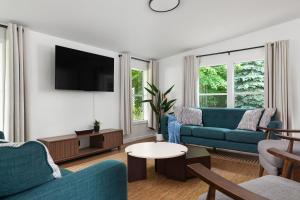 a living room with two blue couches and a tv at Sun & Sand Resort in Port Austin