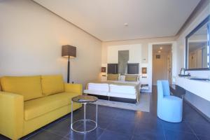 a living room with a yellow couch and a bed at Orka Sunlife Resort Hotel and Aquapark in Oludeniz