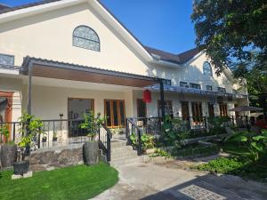 a white house with a gate and a yard at Kooka Residence Surabaya in Surabaya