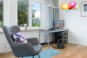 a living room with a chair and a desk with a computer at Treibholz in Schönberg