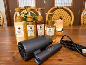 a hair dryer sitting on a wooden table with several bottles at Daiwa House BBQ 琵琶湖徒步3分 無料駐車4台プロジェクター in Takashima