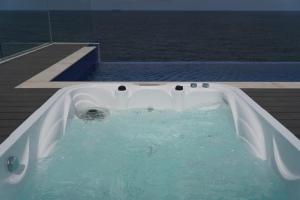 a bath tub on a deck with water in it at Pohang Horizon Poolvilla in Pohang