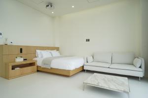 a bedroom with a bed and a couch at Pohang Horizon Poolvilla in Pohang +11 photos