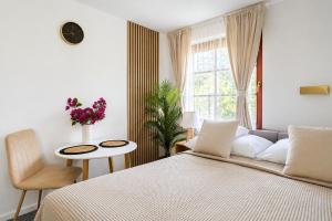 a bedroom with a bed and a chair and a window at Baltic Sand - Apartamenty I Pokoje Władysławowo in Władysławowo