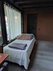 a small bed in a room with a window at Velas del Lago in Piedras Moradas