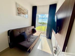 a living room with a couch and a window at Apartamento inteiro em bairro nobre com conforto e ar-condicionado in Boituva