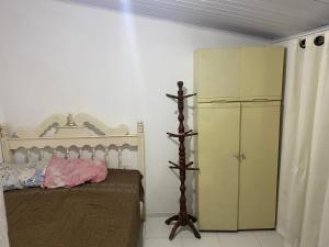a bedroom with a bed and a yellow refrigerator at Casa mobiliada Jabutiana in Aracaju