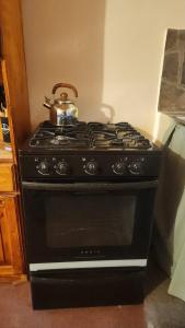 a black stove with a tea kettle on top of it at Cabañas Puesta del Sol in Purmamarca