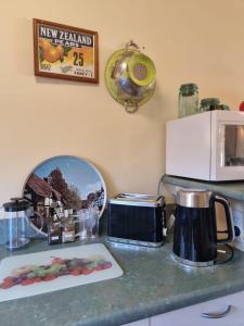 a kitchen counter with a toaster and a microwave at #6 Glenorchy Alpine Suite in Glenorchy