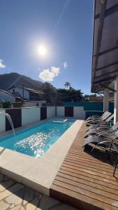 a swimming pool on top of a building with chairs at Pousada Tribo Ubatuba in Ubatuba