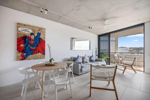 a living room with a superhero painting on the wall at Modern Beach Ocean View 1 BDR Parking Balcony AC in Sydney