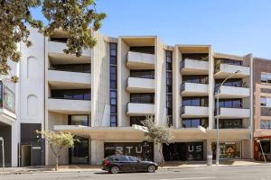 a black car parked in front of a building at Modern Beach Ocean View 1 BDR Parking Balcony AC in Sydney